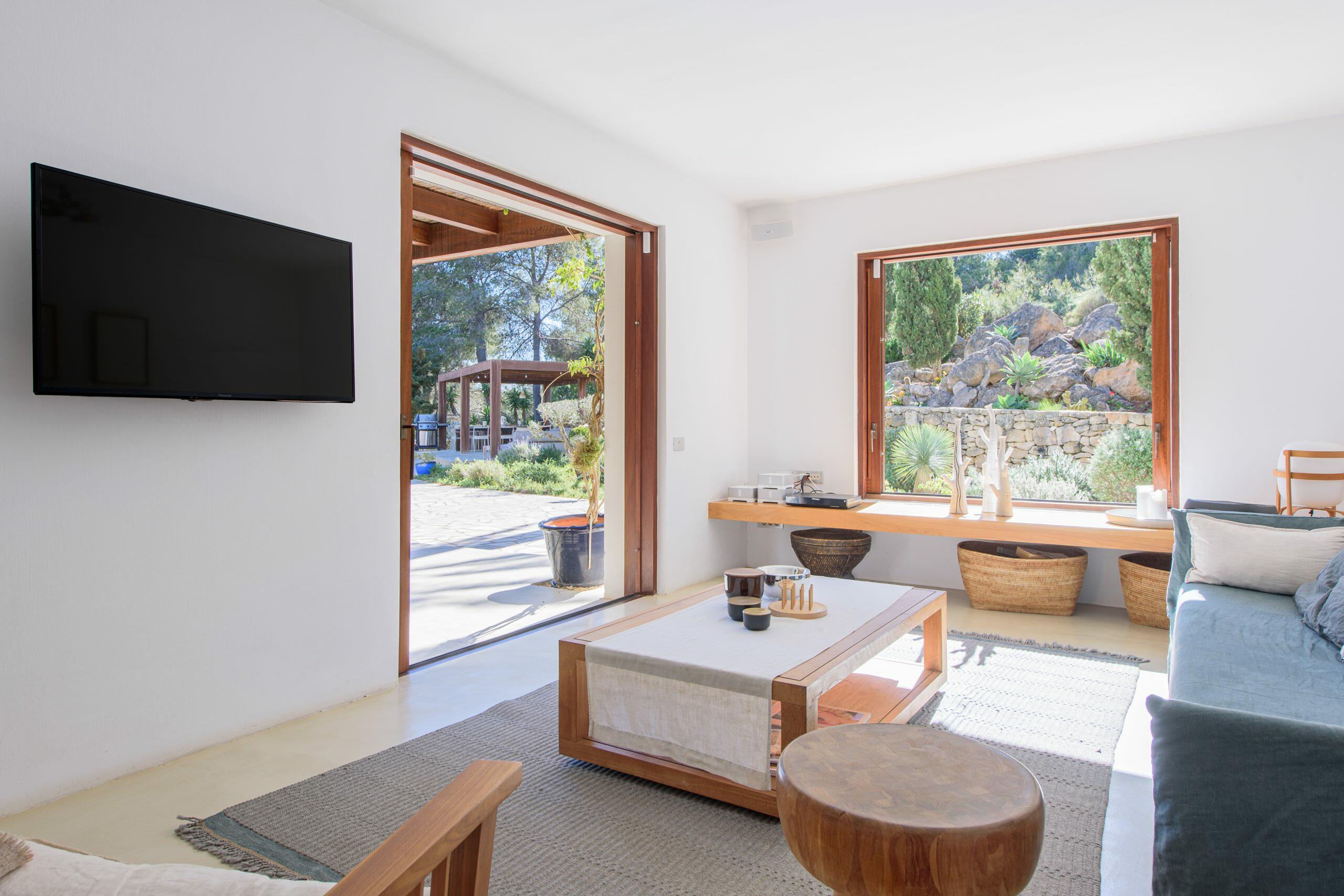 Helles Wohnzimmer in einem Haus auf Ibiza mit großen Öffnungen zum Garten und natürlichem Licht.